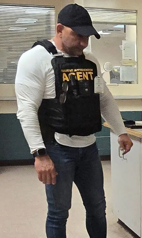 A man wearing a vest that says agent on it